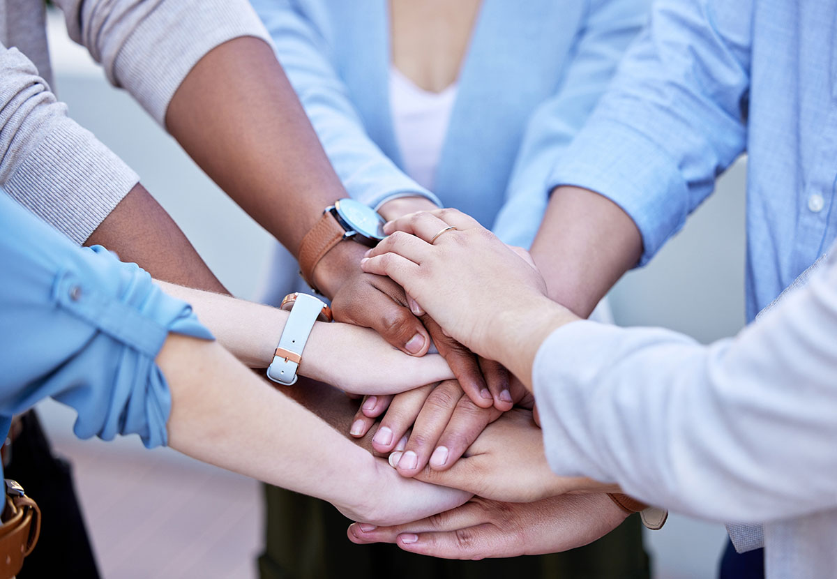 Uplifting one another to great success. Shot of a group of business people with their hands stacked.